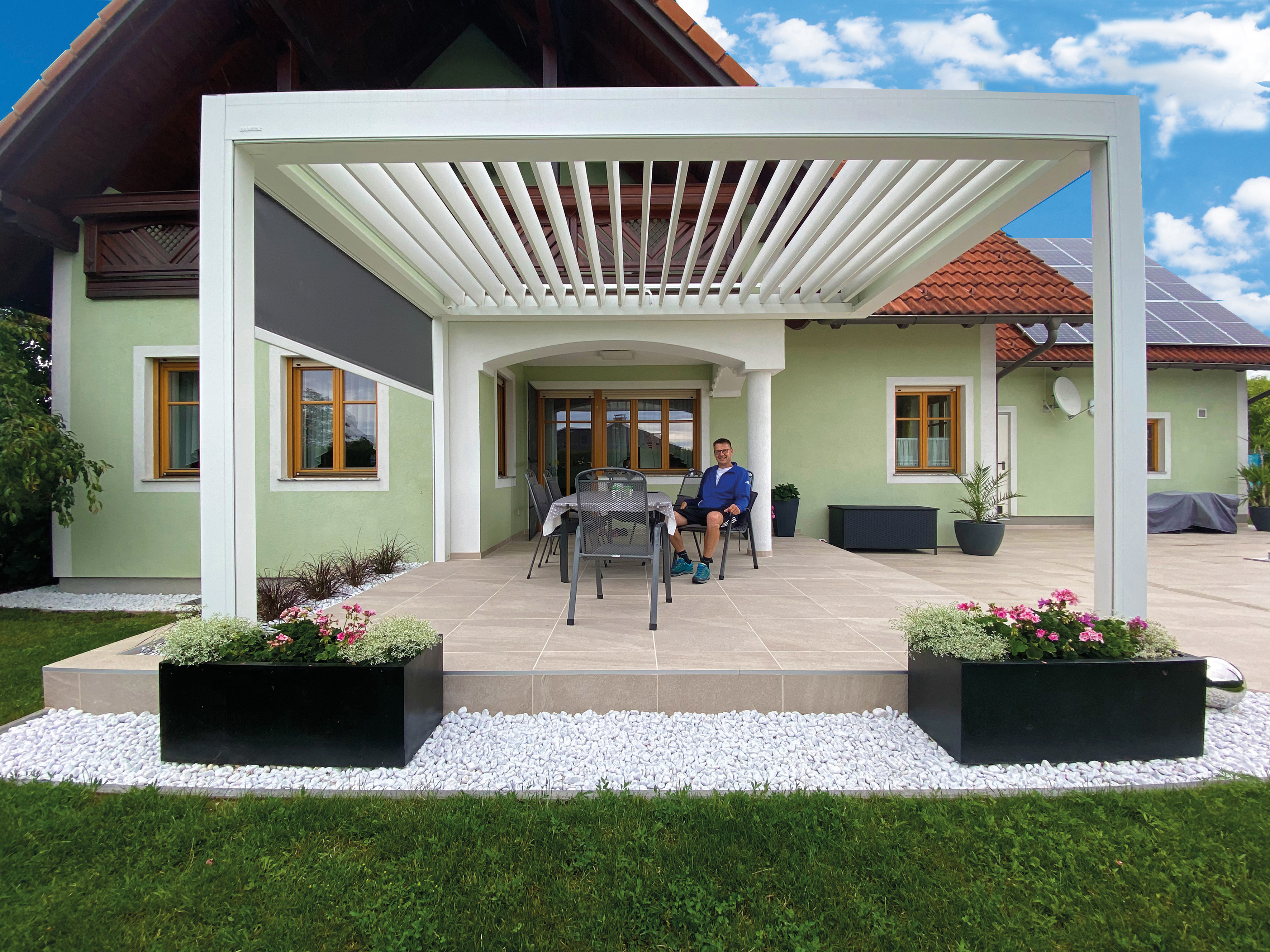 Terrassenüberdachung aus Aluminium mit Lamellen bei einem Einfamilienhaus in Hollabrunn. 