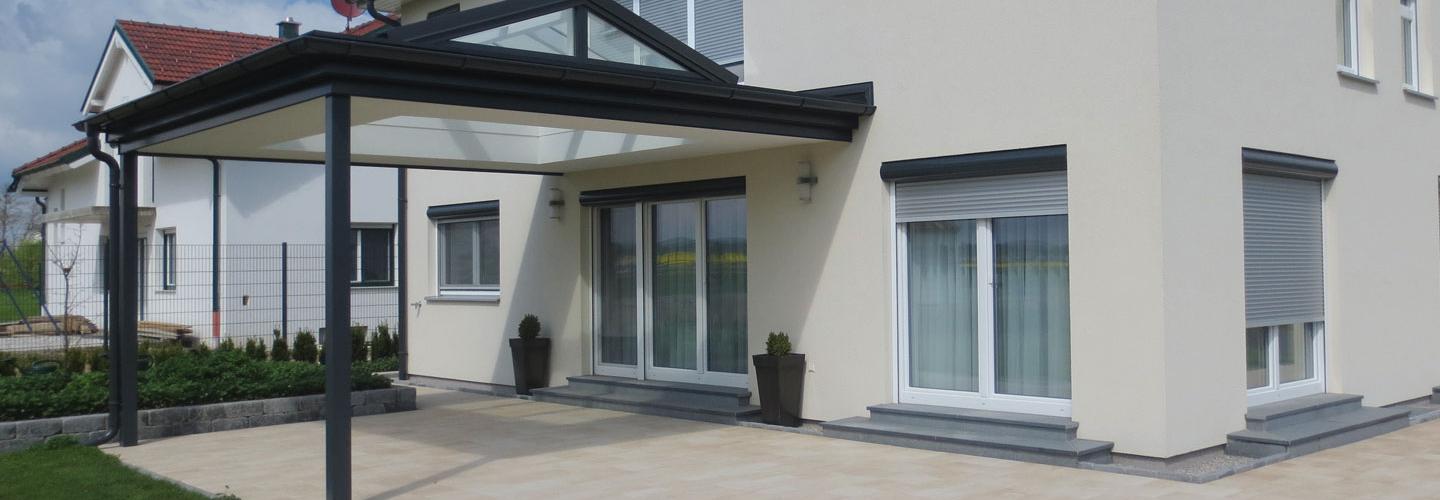 Einfamilienhaus mit beiger Fassade und Terrassenüberdachung in anthrazit für Korneuburg.