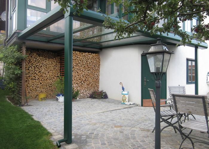 Überdachung in moosgrün mit Glasdach und Sonderform in Tulln.