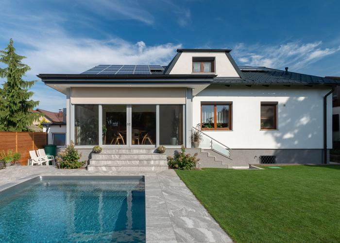 Wintergarten mit raumhohen Hebeschiebetüren mit Stiegen zum Pool in Mödling.
