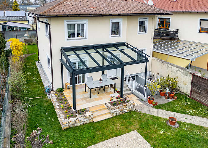 Terrassenüberdachung aus Aluminium mit Glasdach für Sitzbereich im Garten in Bruck an der Leitha