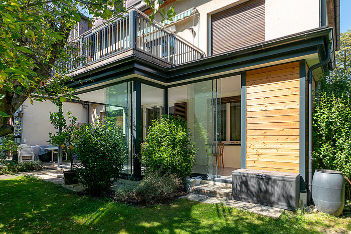 Sommergarten mit Massivdach, Ganzglas-Schiebetüren und Gartenhütte in Mödling.