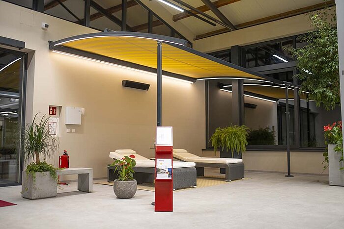 Pergolamarkise aus Aluminium mit gelbem Stoff und LED-Licht.