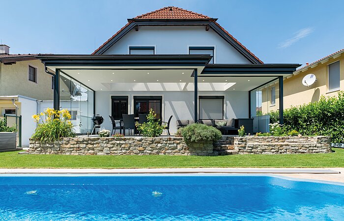Sommergarten mit massivem Dach, Ganzglas-Schiebetüren und Glasgiebel in Wien.